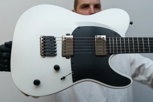 Aristides T/0 White Pearl Satin featuring @lundgrenguitarpickups Covered Black Heaven pickups, a black raw pickguard, and a Schaller-Hannes bridge!