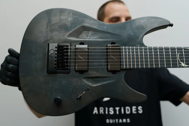 Aristides 070 Worn Steel featuring a custom glow in the dark epoxy inlay, black evertune, and @fishmanmusic Moderns!